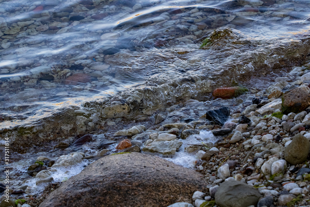 Small beach by the coast covered with multiple stones and sand Small beach by the coast covered with multiple stones and sand