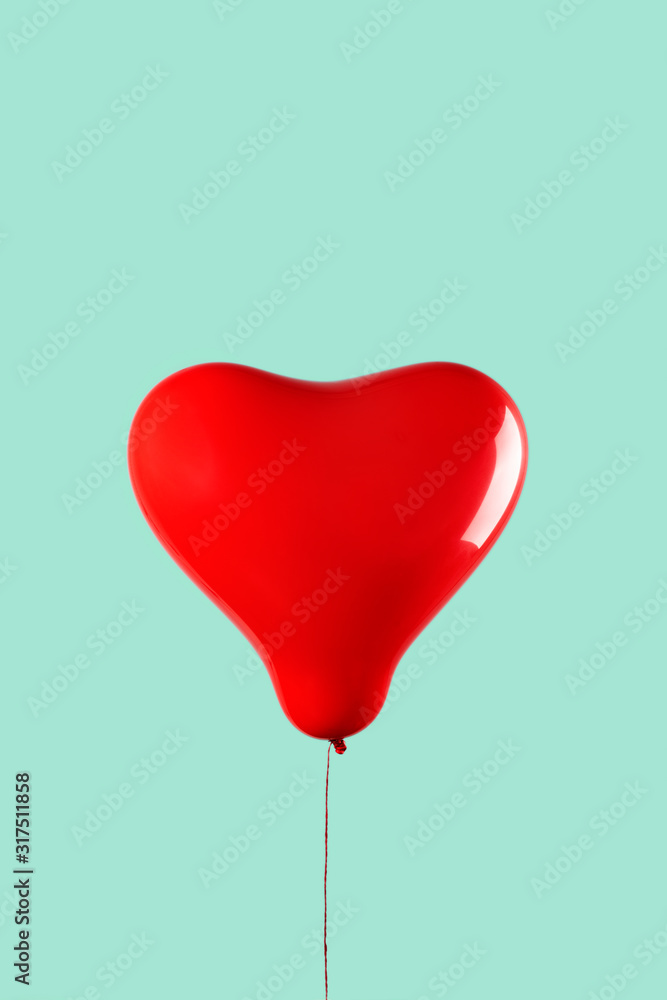 red heart-shaped balloon on a green background red heart-shaped balloon on a green background