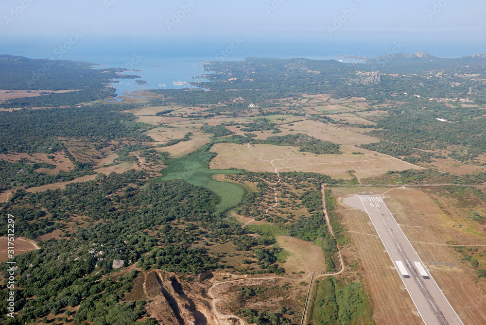 Aerial shot of the Figari Bay and runway from overhead the airfield from the airplane window