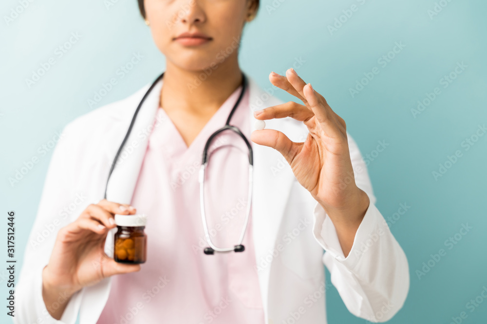 Medical Practitioner With Pill Bottle Against Blue Background Medical Practitioner With Pill Bottle Against Blue Background