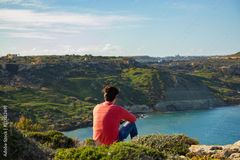 man sitting on cliff enjoy the beautiful scenery