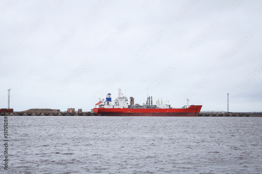 Big red ship in docks. Overcast day in winter.