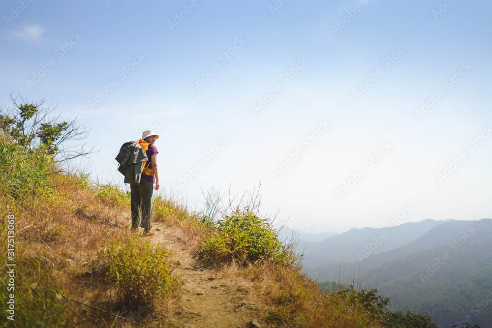 A woman hiker standing on top of mountain