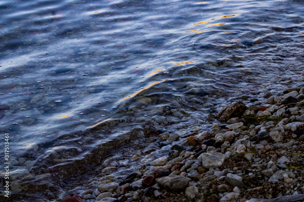 Small beach by the coast covered with multiple stones and sand