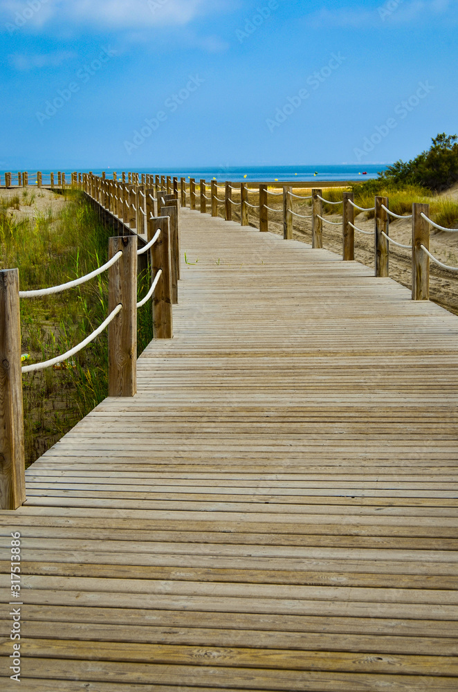 A wooden road leads to the sea