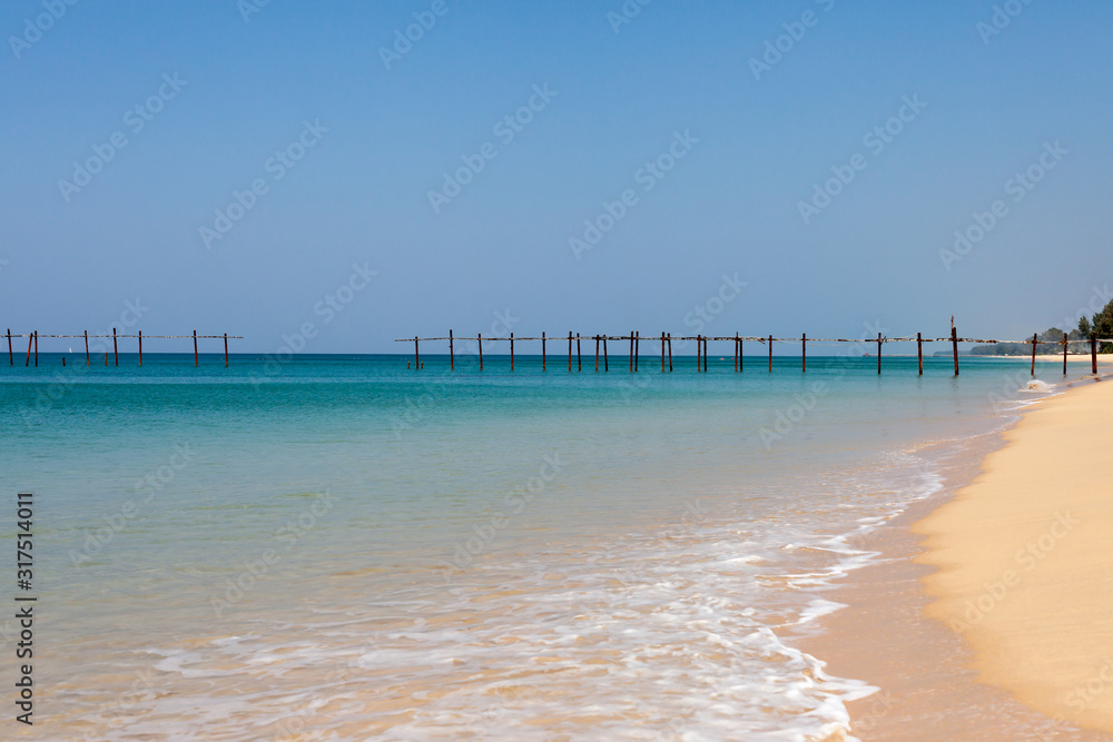 Old wooden bridge in the sea at Khao Pilai Beach in Thailand.