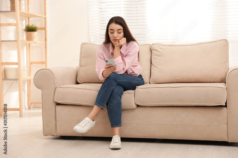 Young woman addicted to smartphone at home Young woman addicted to smartphone at home