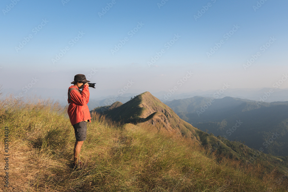 Young male photographer taking photos over the mountain