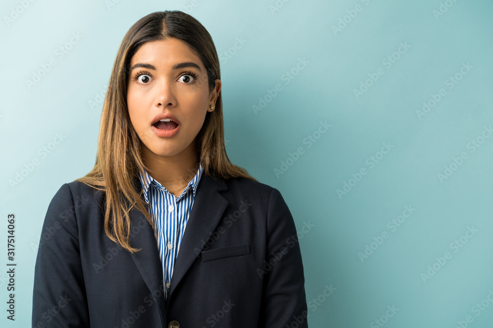 Attractive Latin Female Professional In Shock Against Blue Background Attractive Latin Female Professional In Shock Against Blue Background