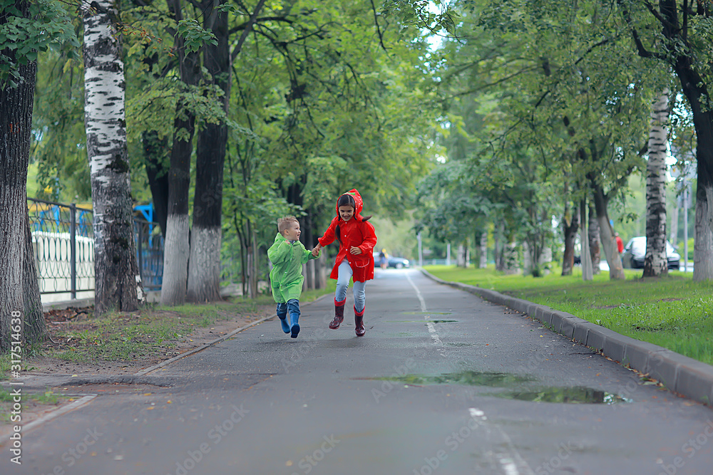 children run in the yellow autumn park rain / fun walk autumn seasonal landscape weather wet