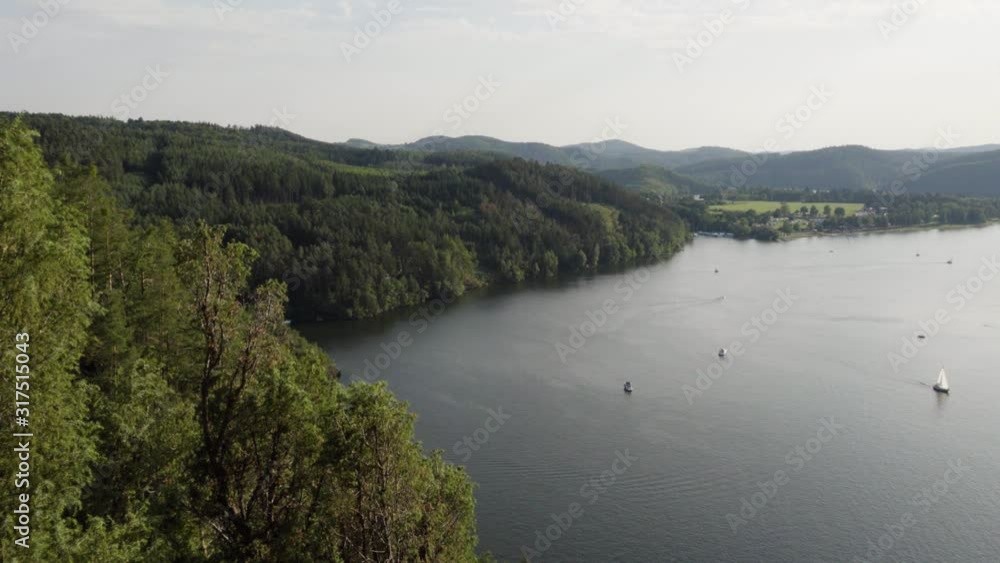 Boats sail on a lake surrounded by nature and mountains. Boats sail on a lake surrounded by nature and mountains.