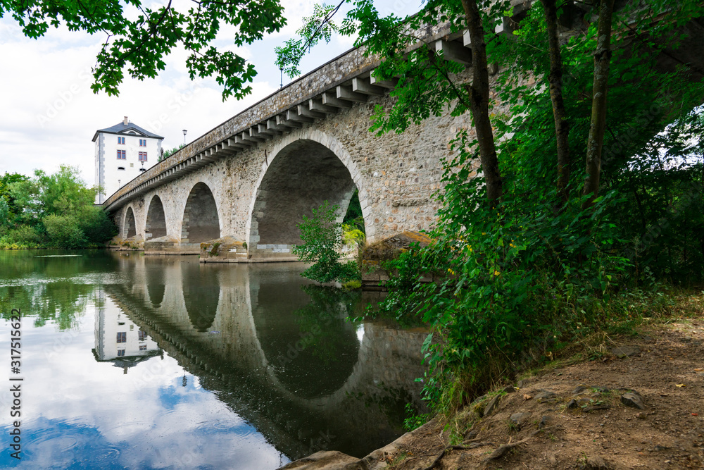 Fototapeta premium Bridge called Alte Lahnbrucke, with reflection in river. In Limburg an der Lahn, Germany 3
