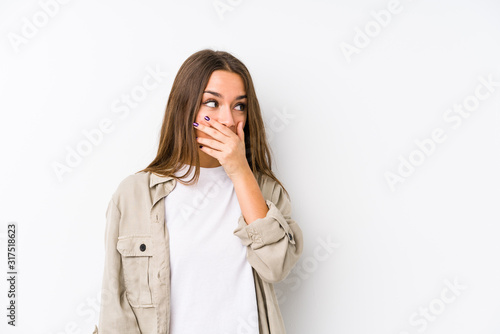 Young caucasian woman  isolated thoughtful looking to a copy space covering mouth with hand.