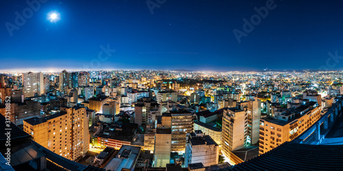 Obraz na plátně Panorama skyview of Porto Alegre city during the night with airplane trail in th