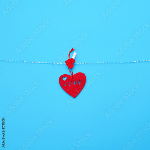 one red felt heart hanging on a white rope and fastened with a clothespin