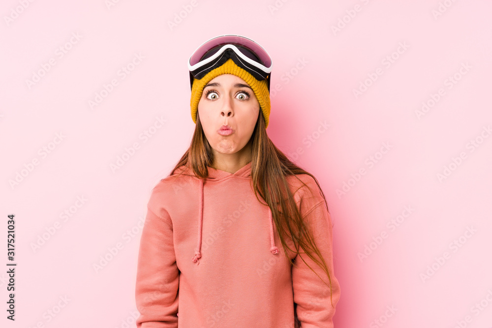 Young caucasian woman wearing a ski clothes isolated shrugs shoulders and open eyes confused. Young caucasian woman wearing a ski clothes isolated shrugs shoulders and open eyes confused.