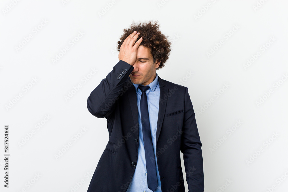 Young business curly man against white background forgetting something, slapping forehead with palm and closing eyes. Young business curly man against white background forgetting something, slapping forehead with palm and closing eyes.