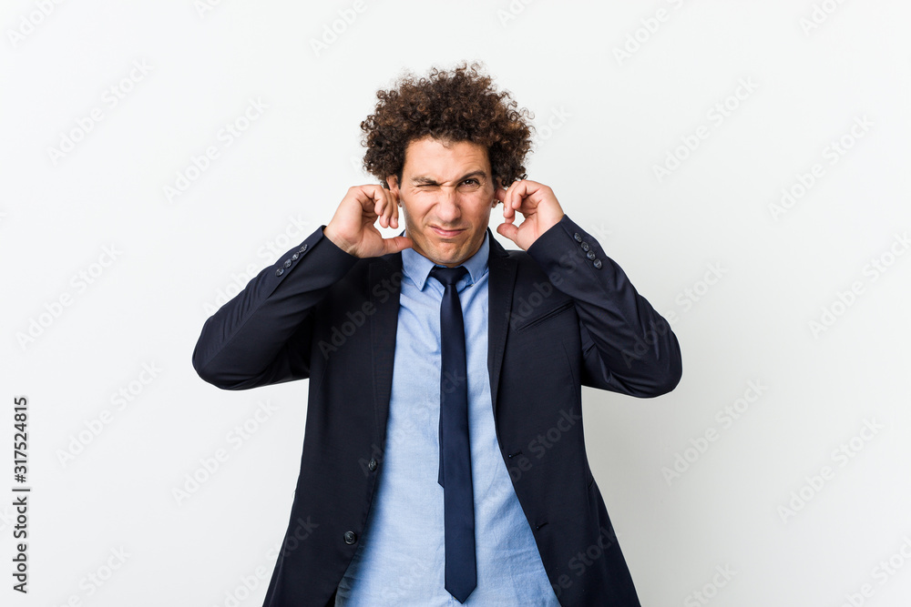 Young business curly man against white background covering ears with hands. Young business curly man against white background covering ears with hands.