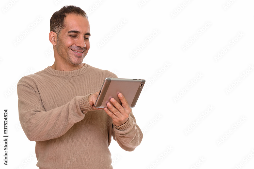 Mature happy Persian man using digital tablet Mature happy Persian man using digital tablet