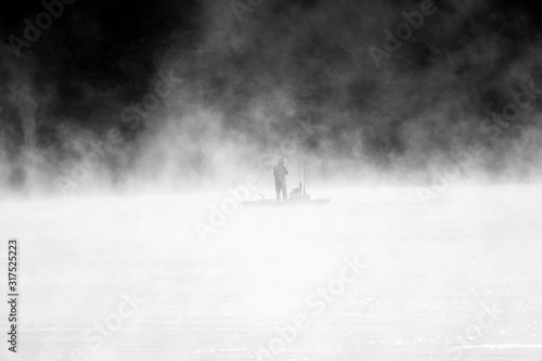 Fisherman in the fog in black and white