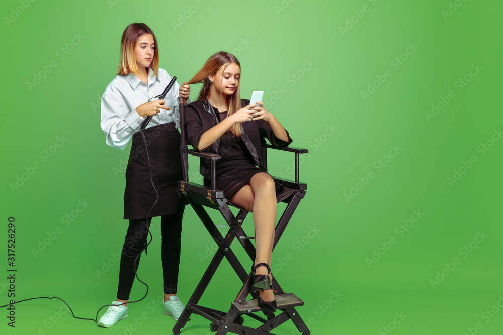 Fototapeta premium First client. Little girl dreaming about profession of hairstyle artist. Childhood, planning, education, dream concept. Wants to become successful employee in fashion and style industry, visage artist