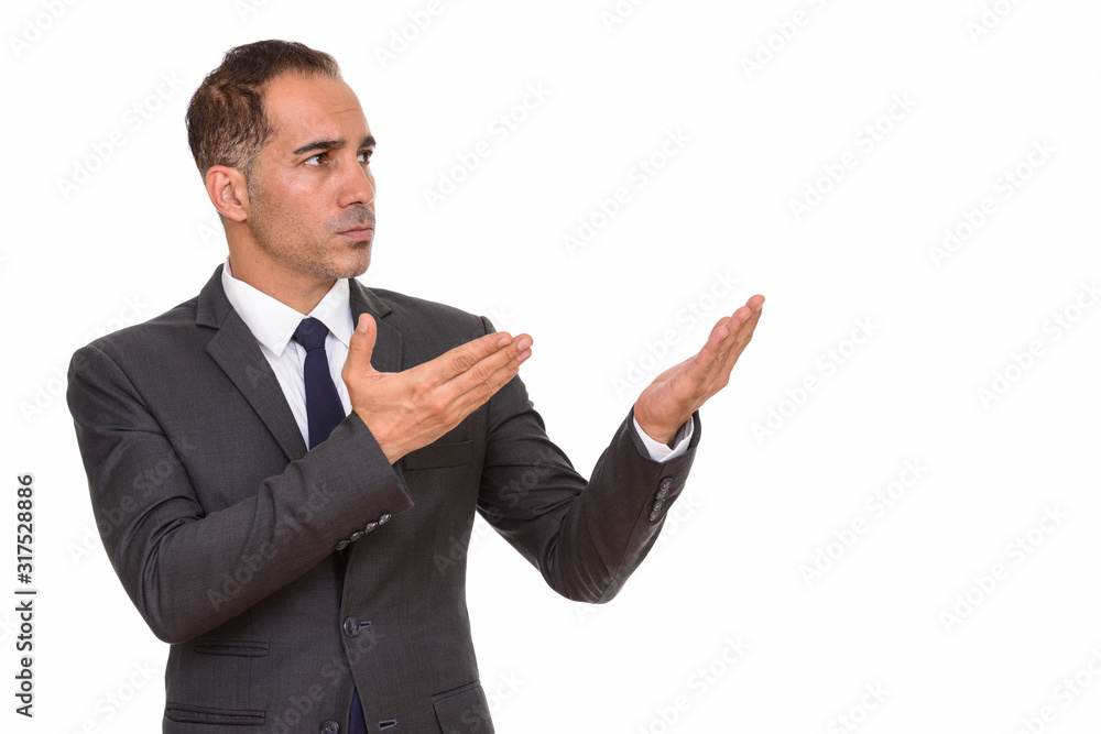 Mature handsome Persian businessman in suit showing something Mature handsome Persian businessman in suit showing something