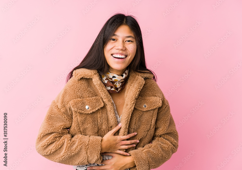 Young asian woman laughs happily and has fun keeping hands on stomach. Young asian woman laughs happily and has fun keeping hands on stomach.