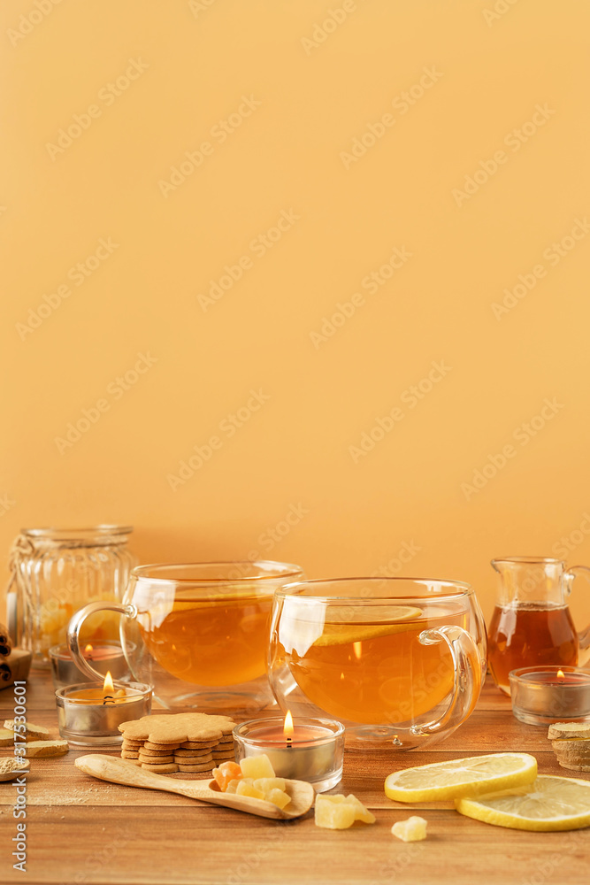 Two cups of tea with lemon, honey, ginger root ingredients and ginger biscuits on wooden table. Natural medicine concept. Mockup for your design. Close-up. Two cups of tea with lemon, honey, ginger root ingredients and ginger biscuits on wooden table. Natural medicine concept. Mockup for your design. Close-up.