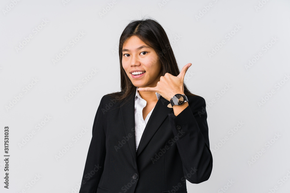 Young asian business woman showing a mobile phone call gesture with fingers. Young asian business woman showing a mobile phone call gesture with fingers.