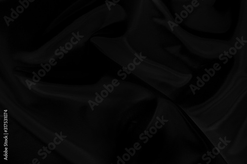 Black gray satin dark fabric texture luxurious shiny that is abstract silk cloth background with patterns soft waves blur beautiful.