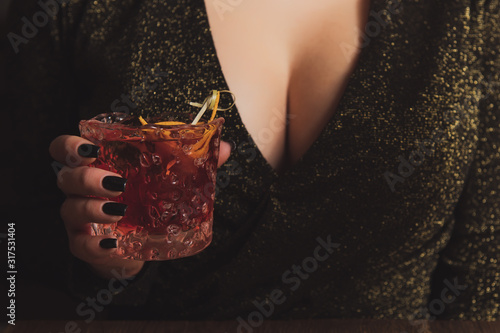 Canvas Print Girl in evening dress with big breast holds an alcohol cocktail in a hand