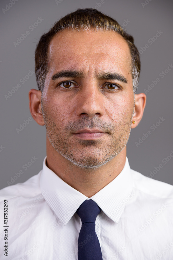 Face of mature handsome Persian businessman looking at camera Face of mature handsome Persian businessman looking at camera