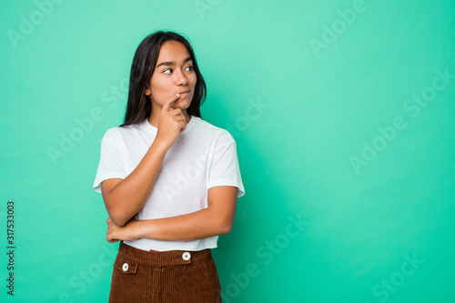 Foto Young mixed race indian woman isolated looking sideways with doubtful and skeptical expression