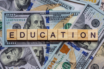 The word education on dollar usa background. College credits, graduation funds, tuition money concept.