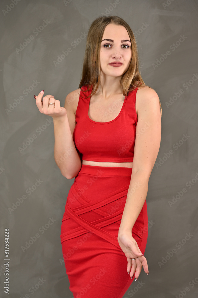 Vertical photo of a pretty smiling girl with long hair and great makeup in a red dress with emotions in different poses. Universal concept of a female portrait. Vertical photo of a pretty smiling girl with long hair and great makeup in a red dress with emotions in different poses. Universal concept of a female portrait.