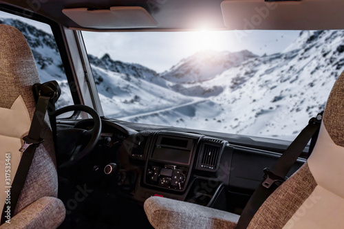 Winter camper with big window and free space for your decoration.Mountains with sun light and snow flakes 