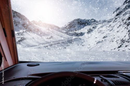 Winter camper with big window and free space for your decoration.Mountains with sun light and snow flakes 