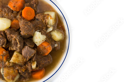 Irish beef stew with carrots and potatoes isolated on white background. Top view. Copy space 