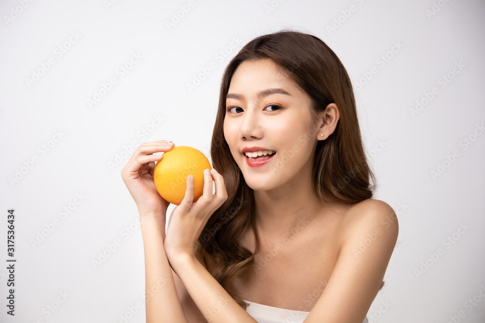 Beautiful Young Asian Woman short hair with Clean Fresh Skin. Face care, Facial treatment, Cosmetology, beauty and healthy skin and cosmetic ideas concept.pretty woman holding half of orange. Beautiful Young Asian Woman short hair with Clean Fresh Skin. Face care, Facial treatment, Cosmetology, beauty and healthy skin and cosmetic ideas concept.pretty woman holding half of orange.