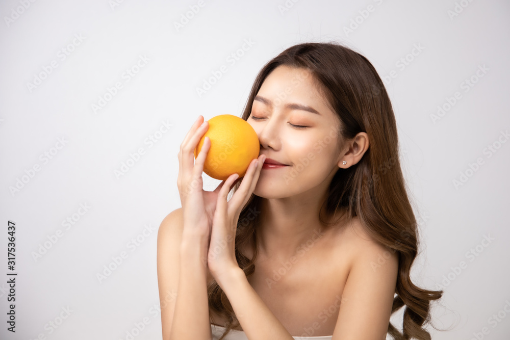 Beautiful Young Asian Woman short hair with Clean Fresh Skin. Face care, Facial treatment, Cosmetology, beauty and healthy skin and cosmetic ideas concept.pretty woman holding half of orange. Beautiful Young Asian Woman short hair with Clean Fresh Skin. Face care, Facial treatment, Cosmetology, beauty and healthy skin and cosmetic ideas concept.pretty woman holding half of orange.