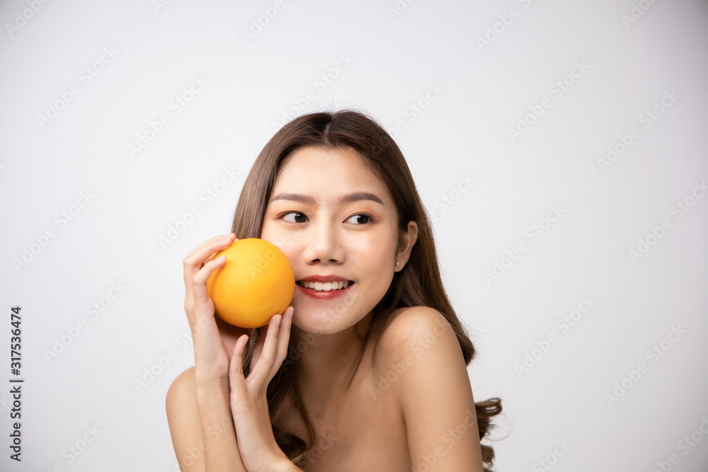Beautiful Young Asian Woman short hair with Clean Fresh Skin. Face care, Facial treatment, Cosmetology, beauty and healthy skin and cosmetic ideas concept.pretty woman holding half of orange. Beautiful Young Asian Woman short hair with Clean Fresh Skin. Face care, Facial treatment, Cosmetology, beauty and healthy skin and cosmetic ideas concept.pretty woman holding half of orange.