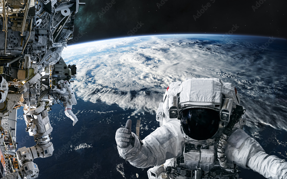 Astronauts and the ISS in orbit of the planet Earth. Solar system. Science fiction. Elements of this image furnished by NASA - obrazy, fototapety, plakaty 