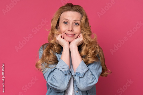 Caucasian mature woman with long hair looking smiling at camera. Studio shot