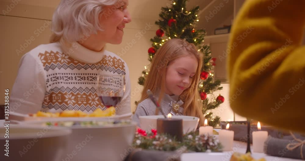 Little caucasian girl granddaughter with grandmother christmas dinner family smile Little caucasian girl granddaughter with grandmother christmas dinner family smile