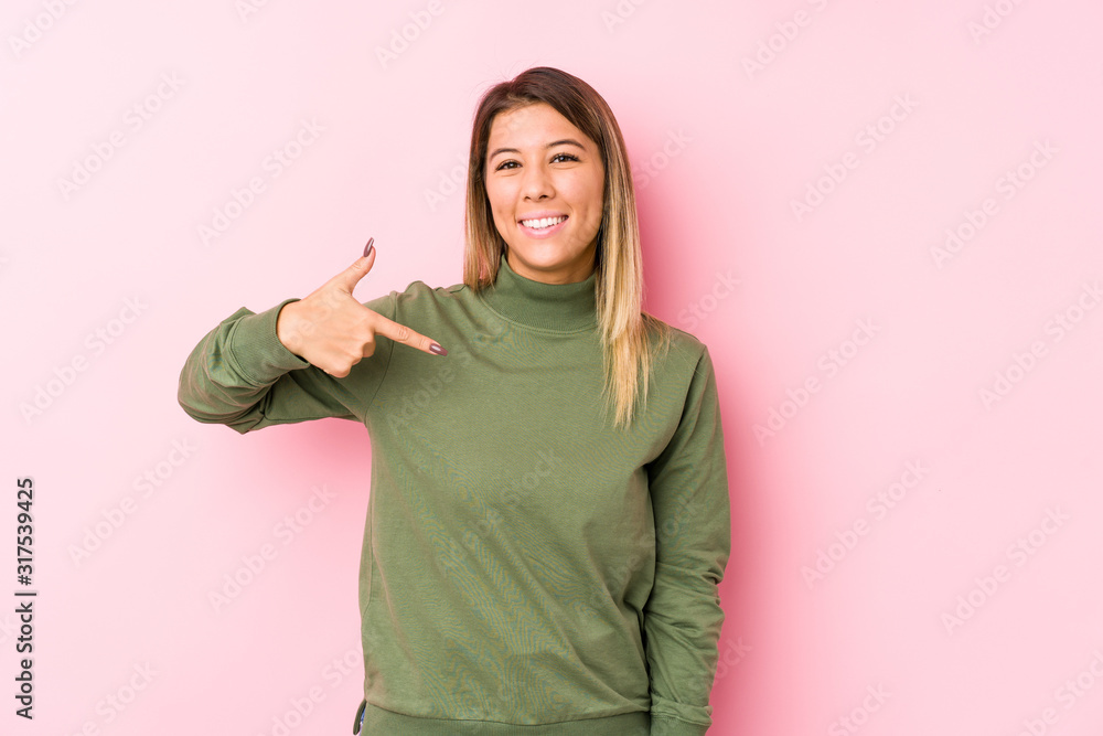 Young caucasian woman posing isolated person pointing by hand to a shirt copy space, proud and confident Young caucasian woman posing isolated person pointing by hand to a shirt copy space, proud and confident
