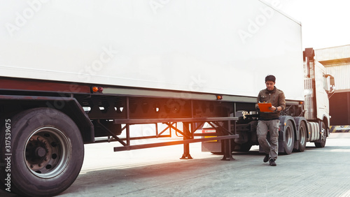 Truck Driver Holding Clipboard is Checking the Truck's Safety Maintenance Checklist. Mechanic Repairman Shop. Inspection of Semi Truck Wheels Tires.Shipping Cargo Freight Truck Transport Logistics.	