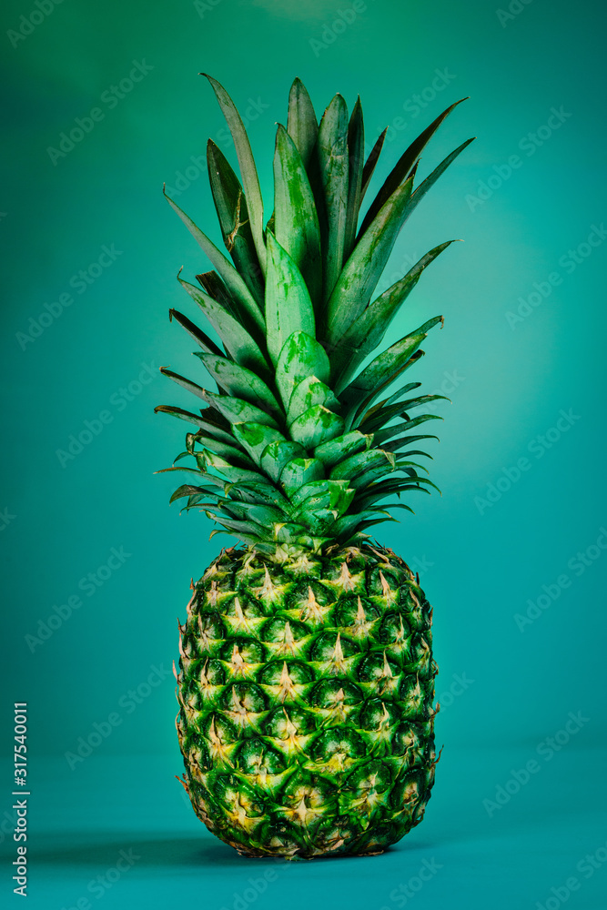 Fototapeta premium Tropical summer background. Pineapple on a blue background. Food concept. Minimal.