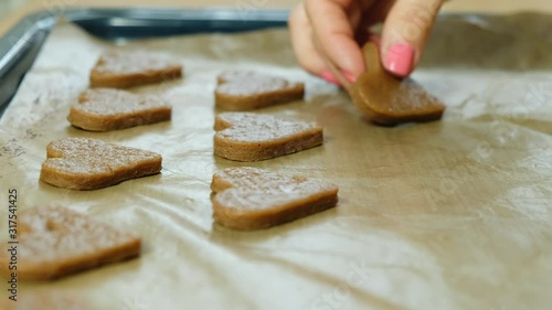 Woman making ginger cookies heart shaped for valentine day or christmas, close up photo