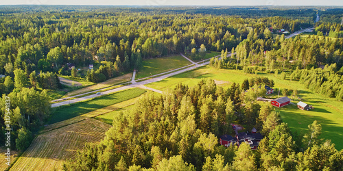 Aerial view of road surrounded by forest in countryside of Finland, Northern Europe