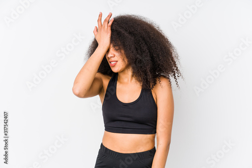 Young african american sporty woman forgetting something, slapping forehead with palm and closing eyes.